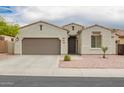 Close up of single-story home with neutral paint, well-manicured front yard and two car garage at 1827 S 237Th Dr, Buckeye, AZ 85326