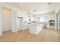 Bright kitchen featuring stainless steel appliances, an island, and white cabinetry, with plank flooring at 1910 E Empeltre Rd, San Tan Valley, AZ 85140