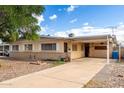 Beige single-story home featuring a covered carport and desert landscaping. The property has a vintage charm at 2331 E Delgado St, Phoenix, AZ 85022