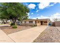 Street view of a vintage beige single-story home with a covered carport and desert landscaping at 2331 E Delgado St, Phoenix, AZ 85022