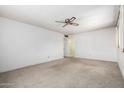 Simple living room with neutral carpet, white walls, and a ceiling fan, awaiting personal touches at 2331 E Delgado St, Phoenix, AZ 85022