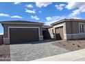 Charming single-story home featuring a paver driveway, multiple garage spaces, and desert landscaping at 24116 N 172Nd Ave, Surprise, AZ 85387