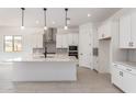 Bright kitchen with stainless steel appliances, large island, and stylish pendant lighting at 24116 N 172Nd Ave, Surprise, AZ 85387