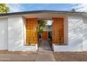 Inviting front entrance with orange decorative screen walls, a tiled walkway, and a matching orange front door at 2632 E Mountain View Rd, Phoenix, AZ 85028