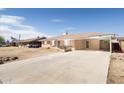 A single-story brick home boasts a large concrete driveway and covered carport, offering ample parking at 2808 W Ocotillo Rd, Phoenix, AZ 85017