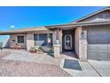 Close up of the front entrance features charming brickwork, a security screen door, and desert landscaping at 3004 W Anderson Dr, Phoenix, AZ 85053