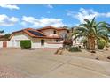 Side view of a home with solar panels, a terracotta roof, a wide driveway, and desert landscaping at 3522 E Fountain St, Mesa, AZ 85213