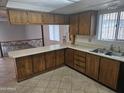 Functional kitchen with wood cabinets, white countertops, and tile floors at 3646 W Mescal St, Phoenix, AZ 85029