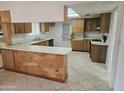 Spacious kitchen featuring wood cabinets, a breakfast bar, and tile flooring at 3646 W Mescal St, Phoenix, AZ 85029