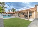 Private backyard retreat featuring a refreshing pool, lush green lawn, and an outdoor dining area at 372 W Larona Ln, Tempe, AZ 85284