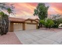 Expansive three-car garage with a long driveway and low maintenance landscaping at 438 E Vaughn Ave, Gilbert, AZ 85234