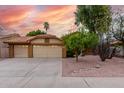 Spacious three-car garage with a well-maintained driveway and low maintenance desert landscaping at 438 E Vaughn Ave, Gilbert, AZ 85234