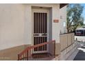 Up-close exterior view of the front door, complete with a security gate and steps leading to the entrance at 7420 E Northland Dr # B101, Scottsdale, AZ 85251