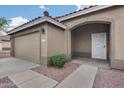 Close-up of a home's arched entryway with a security door and a two-car garage at 9176 N 82Nd Ln, Peoria, AZ 85345