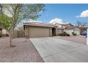 View of a single-Gathering home with a two-car garage, rock landscaping, and a driveway at 9176 N 82Nd Ln, Peoria, AZ 85345