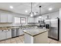 Bright kitchen featuring white cabinets, stainless steel appliances, granite countertops, and a kitchen island at 9176 N 82Nd Ln, Peoria, AZ 85345