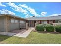 Charming single-story home with a well-manicured lawn and decorative front gate at 10317 W Desert Forest Cir, Sun City, AZ 85351