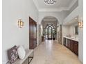 Inviting foyer featuring travertine floors, a wet bar, stone columns, and an arched doorway at 10801 E Happy Valley Rd # 86, Scottsdale, AZ 85255