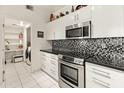 Modern kitchen featuring white cabinets, stainless steel appliances, and stylish black and white backsplash at 11333 N 92Nd St # 1021, Scottsdale, AZ 85260