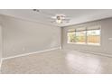 Bright and airy bedroom with tile flooring, a ceiling fan, and a large window at 16425 N 172Nd Ln, Surprise, AZ 85388