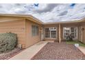 Inviting home entrance with rock garden and table with chairs in covered space at 17443 N 99Th N Dr, Sun City, AZ 85373