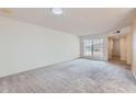 Spacious living room with neutral carpet, white walls and large window, offering a blank canvas for personalization at 17443 N 99Th N Dr, Sun City, AZ 85373