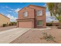 Two story home featuring a two car garage, shutters, landscaped yard, and concrete driveway at 18856 N Comet Trl, Maricopa, AZ 85138