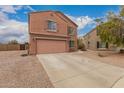 Two story home featuring a two car garage, shutters, landscaped yard, and concrete driveway at 18856 N Comet Trl, Maricopa, AZ 85138