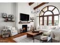 Beautiful living room with a large window, comfortable seating and a cozy fireplace at 18886 N 101St Way, Scottsdale, AZ 85255
