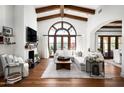 Bright living room boasts a large window, beamed ceilings, a white sofa and a fireplace at 18886 N 101St Way, Scottsdale, AZ 85255