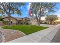 Charming single-story home with a three-car garage, flag pole, and well-manicured lawn at 20497 E Appaloosa Dr, Queen Creek, AZ 85142