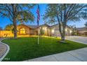Well-manicured lawn and mature shade trees compliment this single-story home with a three-car garage at 20497 E Appaloosa Dr, Queen Creek, AZ 85142