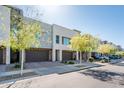 Street view of modern townhomes with individual garages, desert landscaping, and visitor parking at 25339 N 19Th Ln, Phoenix, AZ 85085