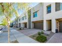 Row of stylish townhouses featuring attached garages and low-maintenance desert landscaping at 25339 N 19Th Ln, Phoenix, AZ 85085