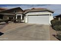 Front view of home with a driveway leading to a two-car garage at 25798 W Miami St, Buckeye, AZ 85326