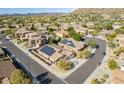 Stunning aerial view of a residential neighborhood with houses with solar panels against a mountain backdrop at 27204 N 86Th Dr, Peoria, AZ 85383