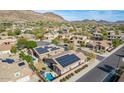 Neighborhood aerial view showcasing homes with solar panels and a backyard with a pool at 27204 N 86Th Dr, Peoria, AZ 85383
