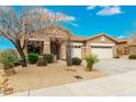 Charming home featuring a three-car garage, desert landscaping, and a tile roof at 27204 N 86Th Dr, Peoria, AZ 85383