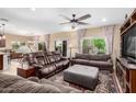 Spacious living room with comfortable seating, a ceiling fan, and large windows offering natural light at 2878 E Tonto Dr, Gilbert, AZ 85298