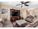 Comfortable living room with plush seating, ceiling fan, and a large entertainment center at 2878 E Tonto Dr, Gilbert, AZ 85298