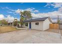 A single-story house with a blue front door, modern windows, and an expansive concrete driveway at 3407 E Hubbell St, Phoenix, AZ 85008