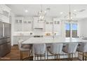 Bright kitchen with white cabinets, island with seating, stainless steel appliances, and pendant lighting at 440 E Aurora Dr, San Tan Valley, AZ 85140
