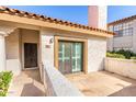 Patio view with stucco walls, red tile roofing, a security door, and a sliding glass door at 6349 N 78Th St # 123, Scottsdale, AZ 85250
