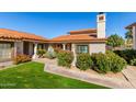 Exterior view of a condo with a red tile roof and lush front yard landscaping at 6349 N 78Th St # 123, Scottsdale, AZ 85250