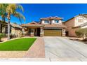 Two-story home featuring a charming front porch, two-car garage, tile roof, and low-maintenance desert landscaping at 650 E Daniella E Dr, San Tan Valley, AZ 85140