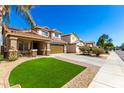 Two-story home featuring a charming front porch, two-car garage, tile roof, and low-maintenance desert landscaping at 650 E Daniella E Dr, San Tan Valley, AZ 85140