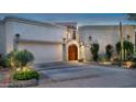 Charming home featuring a custom wood door, desert landscaping, and a two-car garage at 8369 E Del Camino Dr, Scottsdale, AZ 85258
