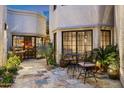 Private outdoor patio with stone floors, a grill, and lush desert plants at 8369 E Del Camino Dr, Scottsdale, AZ 85258