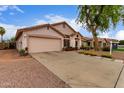 Charming single-story home with a two-car garage, desert landscaping and ample parking on the driveway at 8568 W Purdue Ave, Peoria, AZ 85345