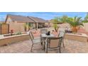 Charming backyard area with a stone patio, dining set, and lush landscaping at 9740 W Rockwood Dr, Peoria, AZ 85382